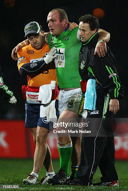 Michael Weyman of the Raiders leaves the field with concussion after a heavy clash with Jeff Lima of the Storm during the round 19 NRL match between...