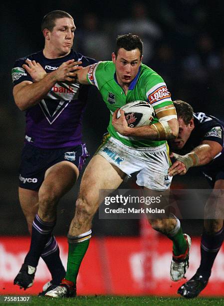 Colin Best of the Raiders makes a line break as Ryan Hoffman of the Storm attempts a tackle during the round 19 NRL match between the Melbourne Storm...