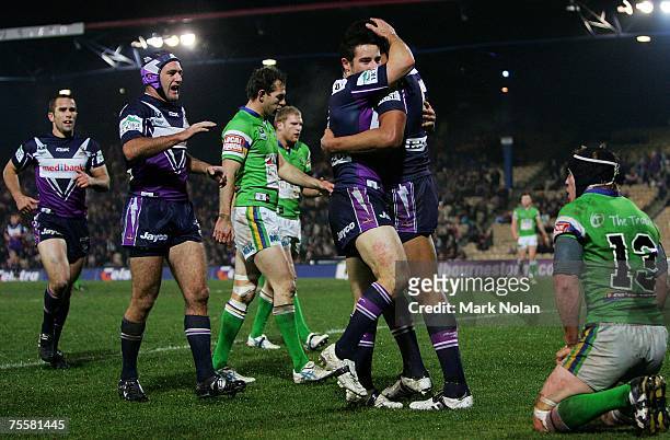 Storm players rush to congratulate Isael Folau after he scored during the round 19 NRL match between the Melbourne Storm and the Canberra Raiders at...