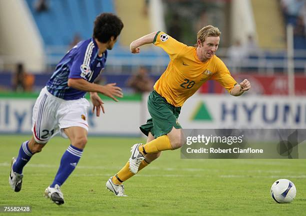 David Carney of Australia gets to the ball ahead of Akira Kaji during the AFC Asian Cup 2007 Quarter Final between Japan and the Australian Socceroos...