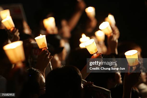 South Koreans hold candles during a candle-lit vigil demanding withdrawal of South Korean troops from Afghanistan and return of kidnapped South...
