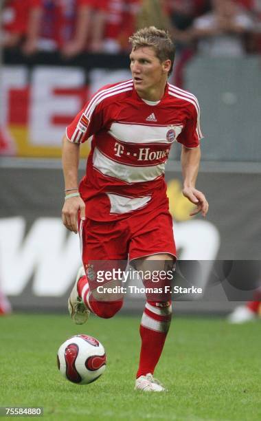 Bastian Schweinsteiger of Munich runs with the ball during the Premiere Liga Cup match between SV Werder Bremen and Bayern Munich at the LTU Arena on...