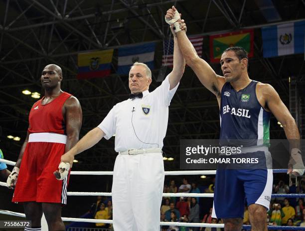 Rio de Janeiro, BRAZIL: The referee raises the arm of Antonio Nogueira of Brazil at the end of the Superheavyweight preliminary round fight against...