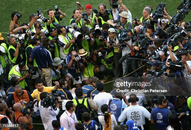 David Beckham of the Los Angeles Galaxy sits on the bench as photographers take his picture before the World Series of Football match against Chelsea...