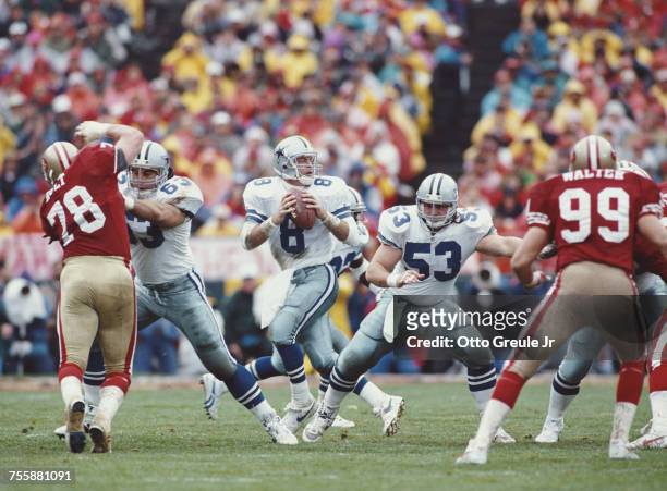 Troy Aikman, Quarterback for the Dallas Cowboys prepares to throw as offensive lineman Mark Stepnoski covers during the National Football Conference...