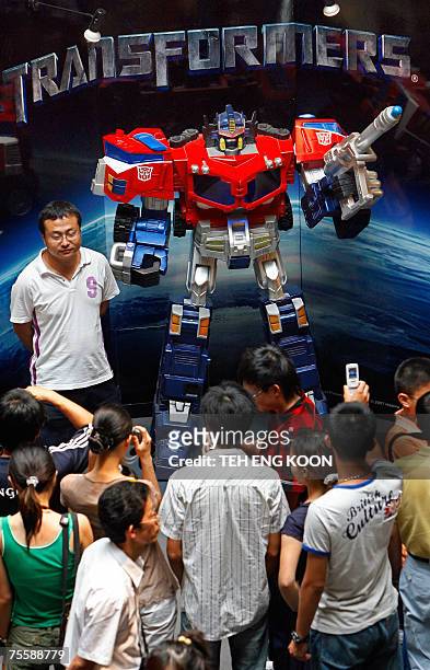 Chinese fans surround a "Transformers" displayed during a Transformers Expo at a shopping mall in Beijing, 22 July 2007. Prices of "Transformers"...