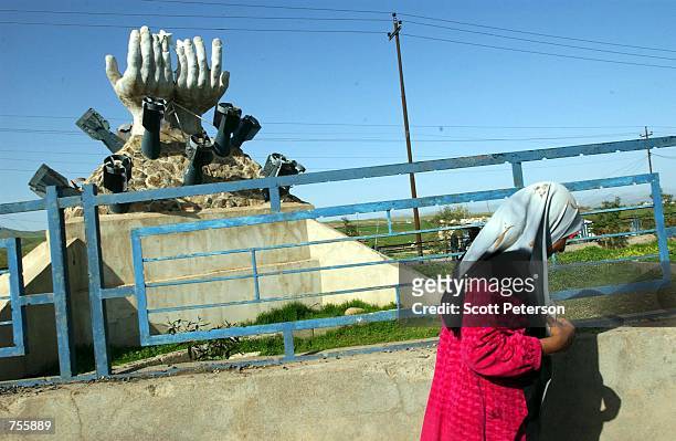 Kurdish woman walks by a memorial to the Iraqi regime's March 16, 1988 gas attack on the Kurdish city of Halabja - which killed 5,000 people - March...
