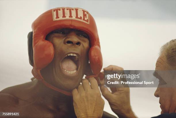 English heavyweight boxer Frank Bruno pictured having his head guard adjusted by his trainer George Francis during a training session at his Arizona...