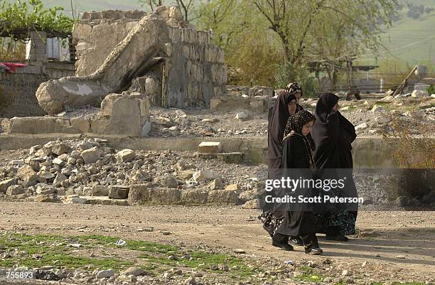 Locals walk past some of the rubble that remains after the Iraqi regime's March 16, 1988 gas attack on the Kurdish city of Halabja - which killed...