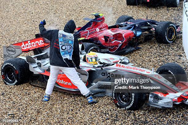 Lewis Hamilton of Great Britain and McLaren Mercedes and the car of Scott Speed of United States and Scuderia Toro Rosso sit in the gravel after...