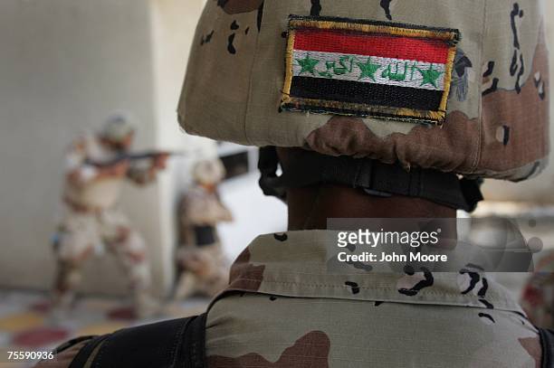 An Iraqi flag adorns a helmet as Iraqi Army troops from the Muthana Brigade train July 22, 2007 at a base on the outskirts of Baghdad, Iraq....