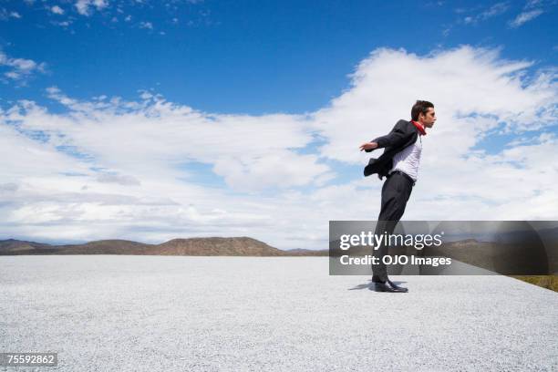 man leaning into the wind - leaning stock pictures, royalty-free photos & images