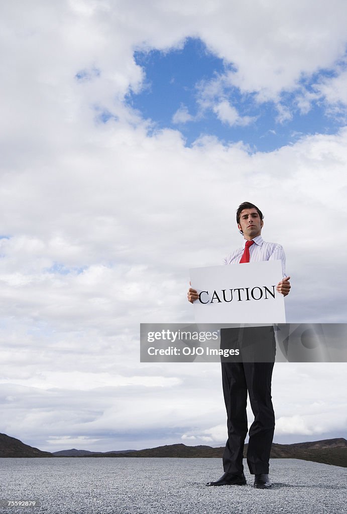 Man holding a caution placard