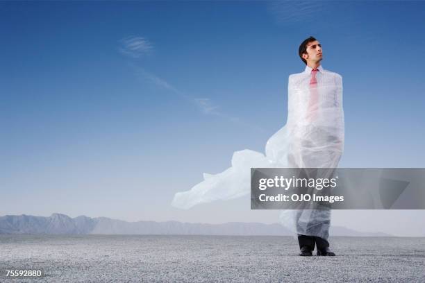 man outdoors ensnared in a sheer sheet - bubble wrap stock pictures, royalty-free photos & images