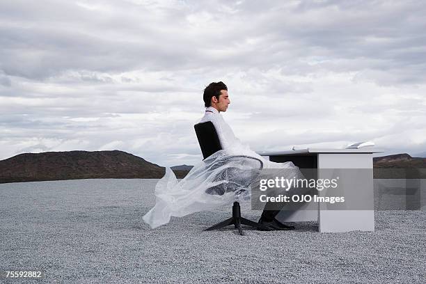 man outdoors ensnared in a sheer sheet - man tied to chair stockfoto's en -beelden