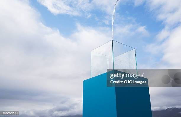 water being poured into a blue receptacle box outdoors - glass box stockfoto's en -beelden