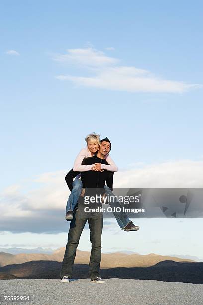 man giving woman a piggy-back ride - girlfriend stock pictures, royalty-free photos & images