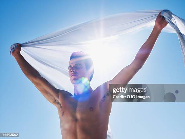 young man holding a sheer sheet - sheer fabric 個照片及圖片檔