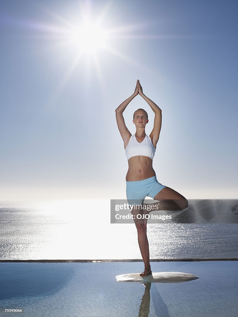 Donna facendo yoga da giochi d'acqua
