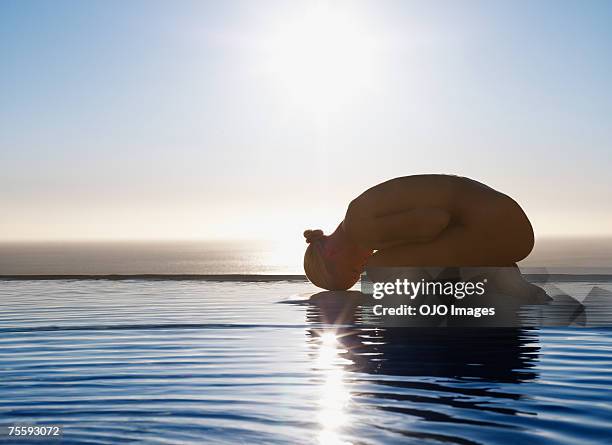 woman in fetal position on tranquil water - hugging knees stock pictures, royalty-free photos & images