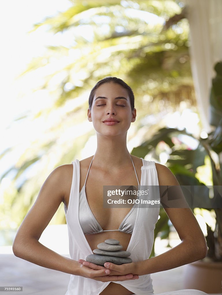 Woman meditating with a pile of stones