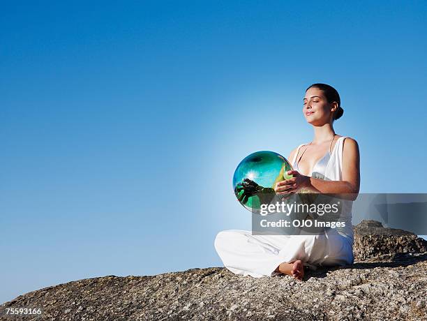 a woman holding an orb - fortune telling stock pictures, royalty-free photos & images