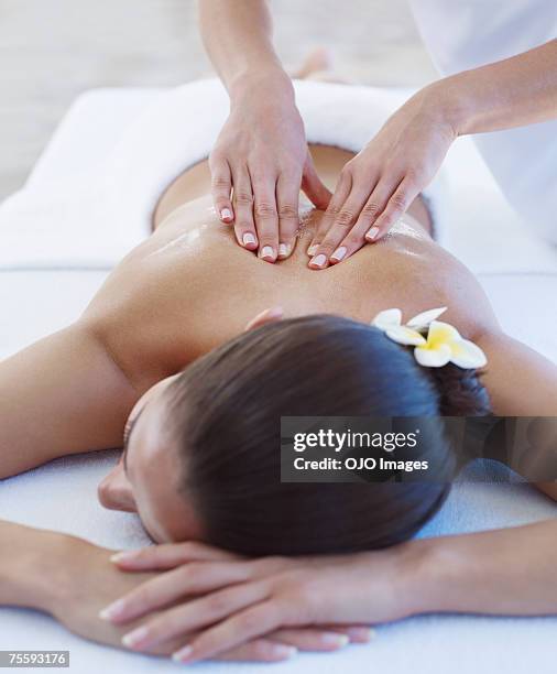 masseuse giving a woman a back massage - healing hands stock pictures, royalty-free photos & images