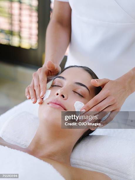 woman receiving a facial treatment - masker stockfoto's en -beelden