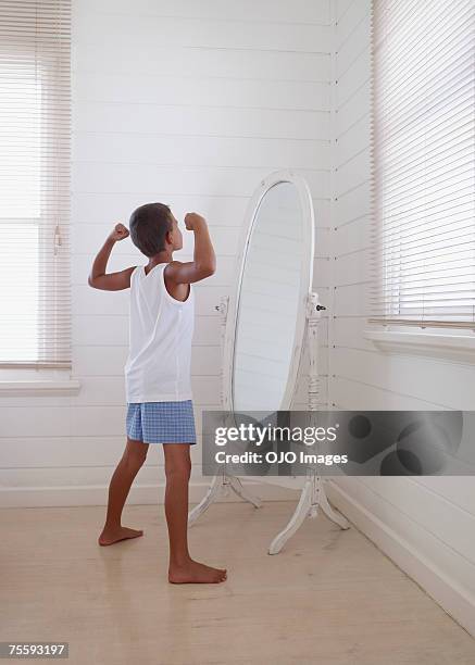 young boy flexing his biceps in front of a mirror - in front of stock pictures, royalty-free photos & images