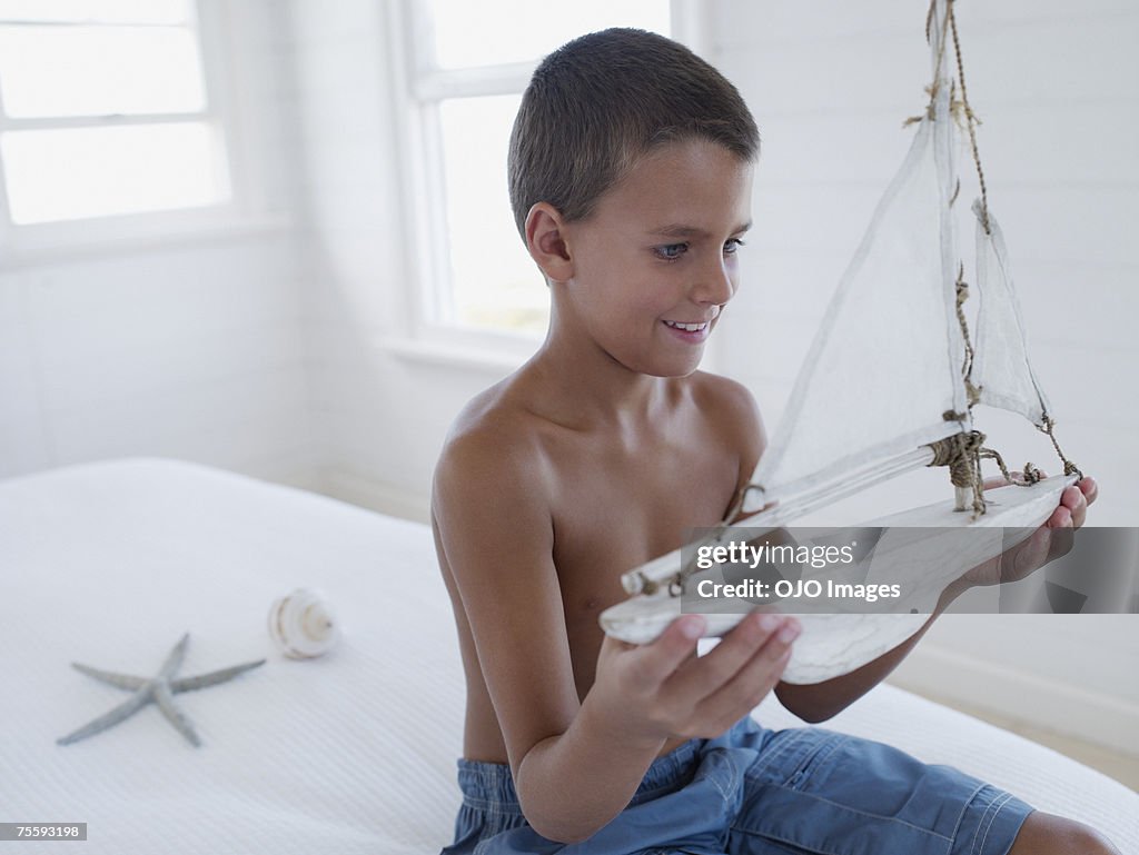 Young boy holding a ship model