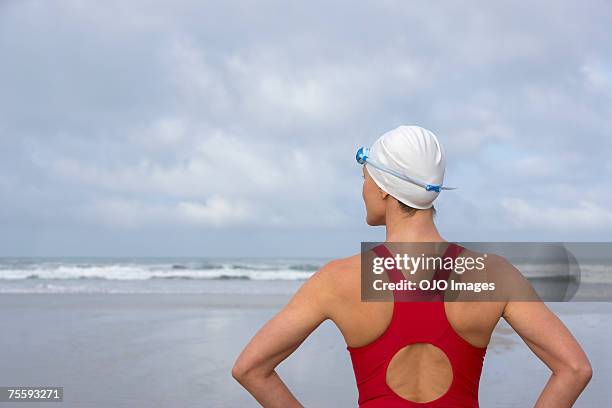 mulher na praia com vista para o mar - touca de natação - fotografias e filmes do acervo