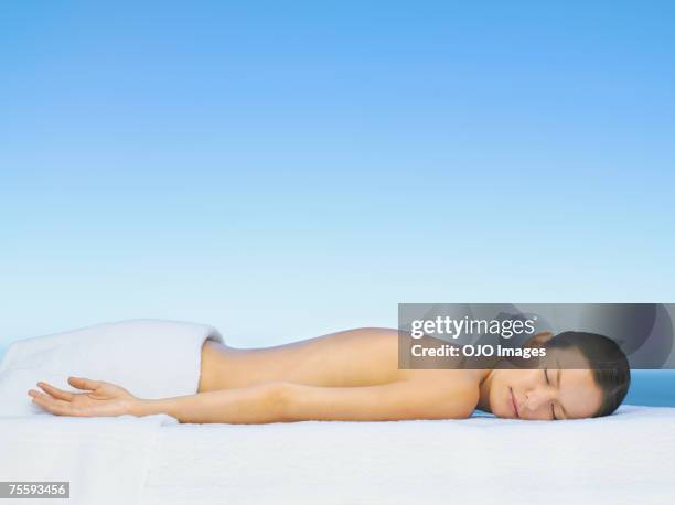 femme détente sur une table de massage - allongé sur le devant photos et images de collection