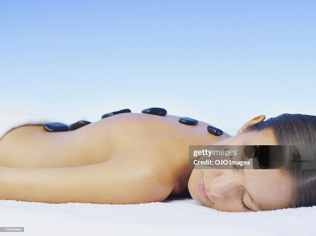 Woman relaxing with massage stones on her back