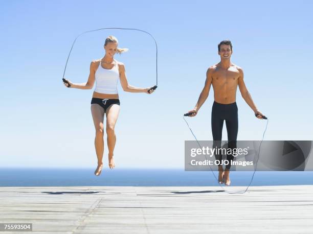 a man and a woman working out with jump ropes - jump rope stock pictures, royalty-free photos & images