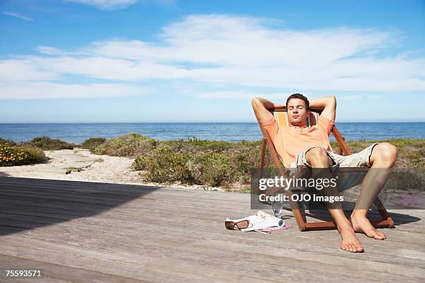 man relaxing in a lounge chair - comfy chair stock pictures, royalty-free photos & images