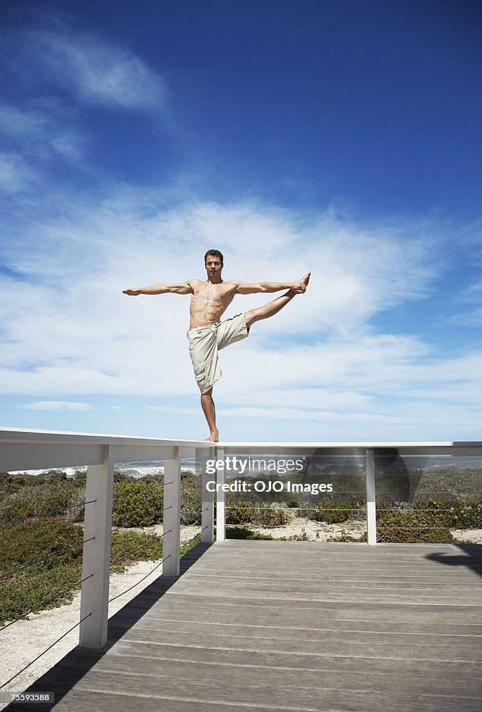 A man balancing on the rail of a terrace