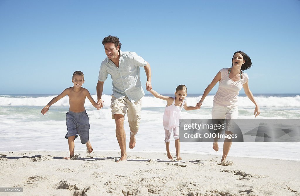 A family on the beach holding hands