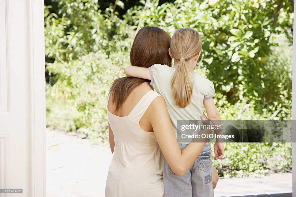 A mother and daughter embracing looking at some wildlife