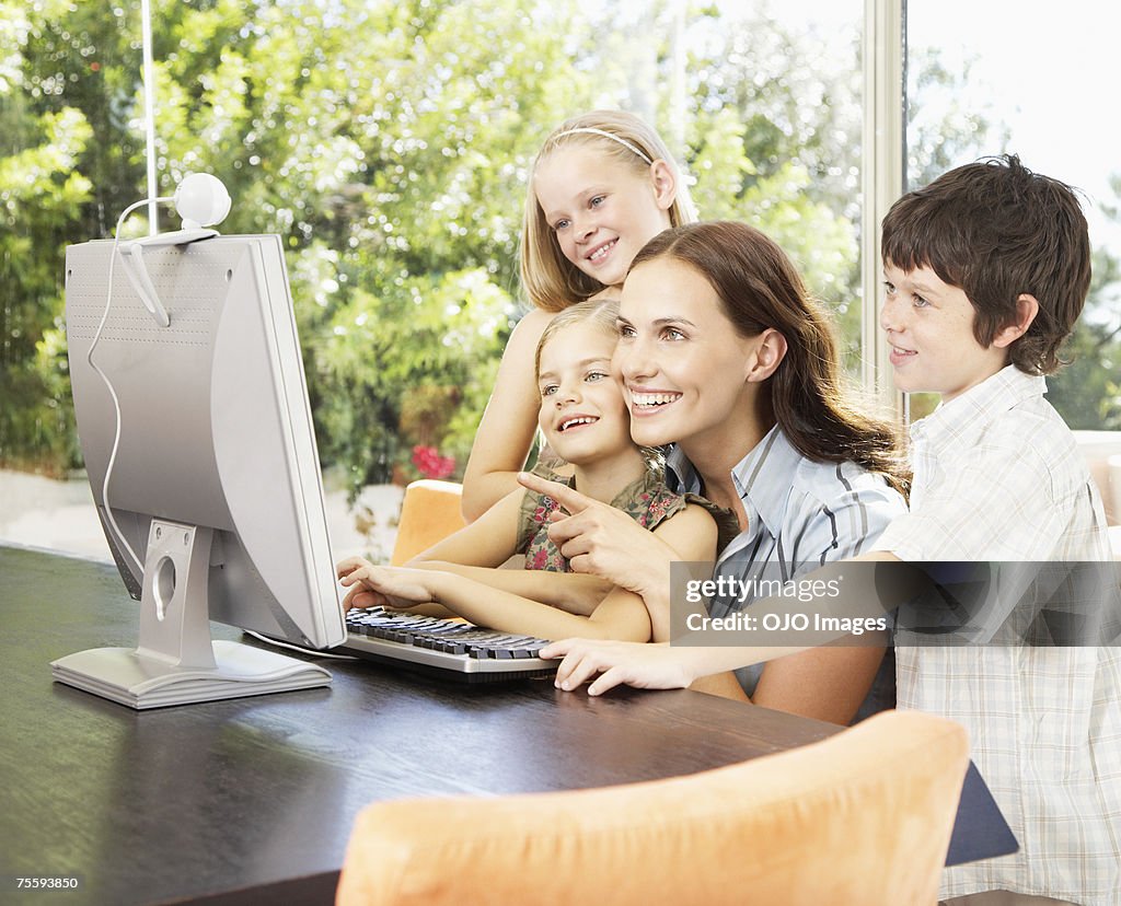 母、コンピュータを使用して 3 つの子供たち