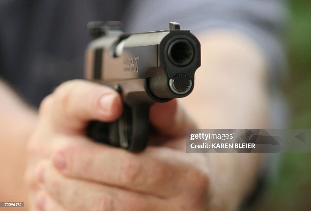 An unidentified man holds a Colt .45 sem...