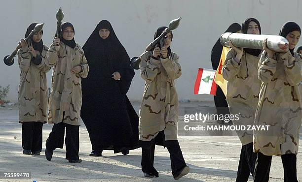 Lebanese youths and supporters of Hezbollah, clad in military fatigues, carry models of Katyusha rocket and Rocket Propelled Grenade launchers during...