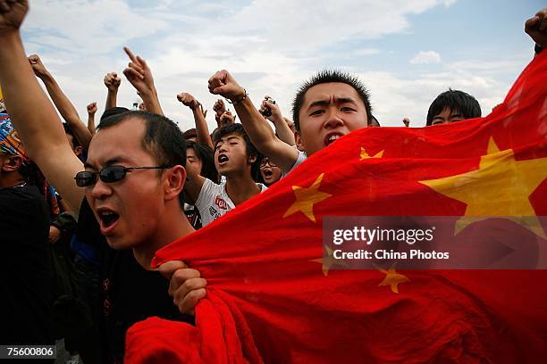 Fans display a Chinese national flag at the first "Green Flag - Erdos Grassland Rock Music Festival" near the Mausoleum of Genghis Khan on July 21,...