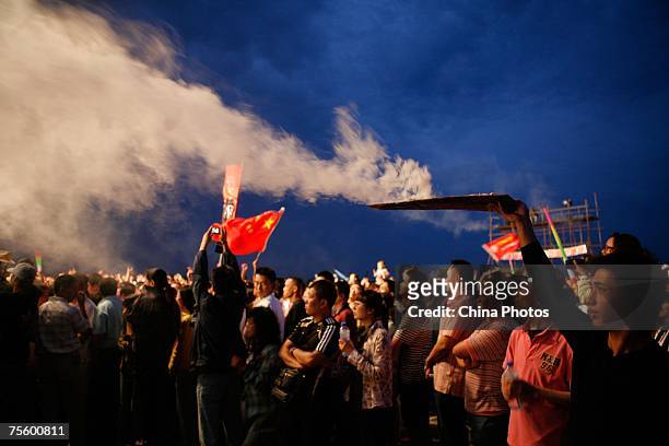Worker makes smoke to heat up the atmosphere at the first "Green Flag - Erdos Grassland Rock Music Festival" near the Mausoleum of Genghis Khan on...