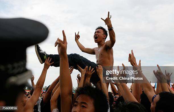 Fans cheer at the first "Green Flag - Erdos Grassland Rock Music Festival" near the Mausoleum of Genghis Khan on July 21, 2007 in Erdos of Inner...