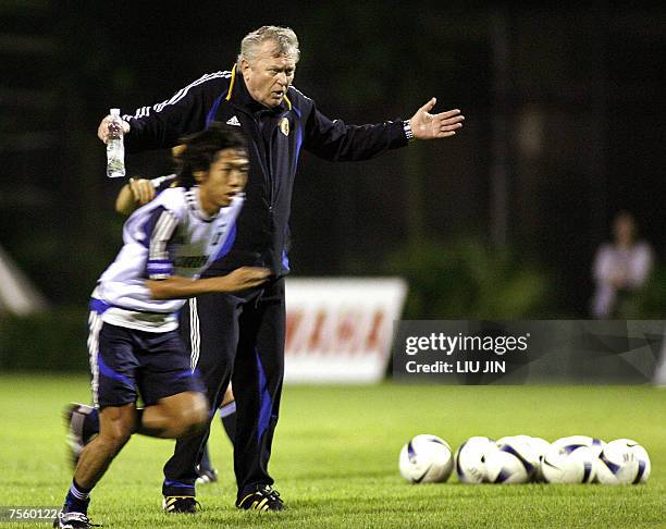 Japan's football team head coach Ivica Osim of Bosnia gives an instruction to players while Kengo Nakamura runs past him during a training session in...