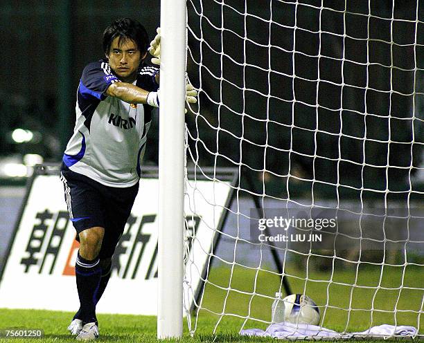 Japanese goalkeeper Yoshikatsu Kawaguchi stretches during a team training session in Hanoi, 23 July 2007. Japan defeated Australia in the...