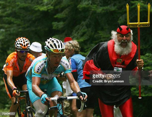 Self-appointed 'Devil of the Tour de France' Didi Senft gives Alexandre Vinokourov of Germany and Astanasome encouragement during stage 15 of the...