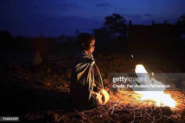 Luciana Malunga, age 8, lights a fire outside the family house on August 18, 2006 in Mphandula village, about 30 miles outside Lilongwe, Malawi....