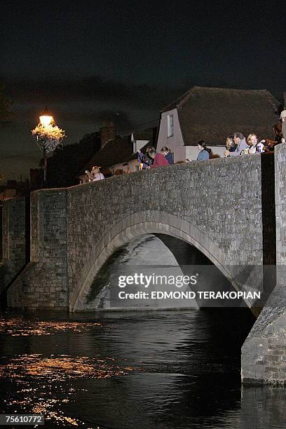 Abingdon, UNITED KINGDOM: A picture taken late 23 July 2007 shows residents watching as the River Ock rises in Abingdon. Britain's emergency...