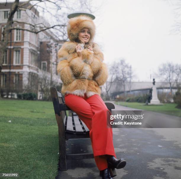 Australian pop singer Olivia Newton-John wearing a heavy fur coat outside the Savoy Hotel in London, circa 1970.